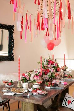 an image of a table setting with candles and flowers on it for a birthday party