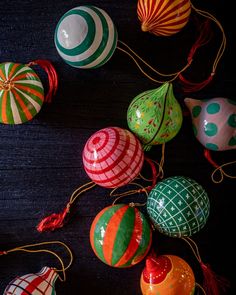 many colorful ornaments are hanging from strings on the table