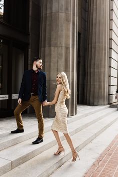 a man and woman are walking down some steps