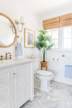 a bathroom with a toilet, sink and mirror