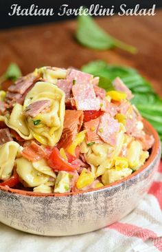 a bowl filled with pasta salad on top of a red and white checkered table cloth