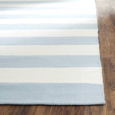 a blue and white striped rug sitting on top of a wooden floor