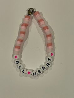 a pink and white beaded bracelet that says, all i hear