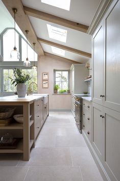 a large kitchen with skylights above the counter tops and cabinets on either side of the room