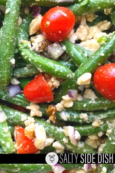 green beans, tomatoes and other vegetables are mixed together in a salad that is ready to be eaten