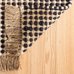 a black and white checkered rug on top of a wooden floor next to a wood floor