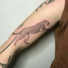 a cheetah tattoo on the left arm