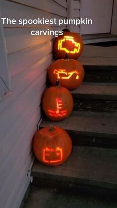 three carved pumpkins sitting on the side of a house with words written in them