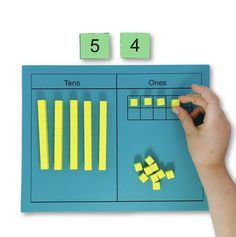 a hand is writing numbers on a blue board with yellow sticky notes attached to it