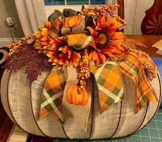 a decorative pumpkin decorated with sunflowers and burlocks