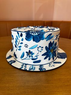 a blue and white cake sitting on top of a wooden table