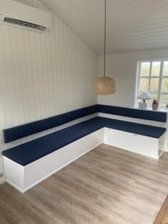 an empty room with white walls and blue benches