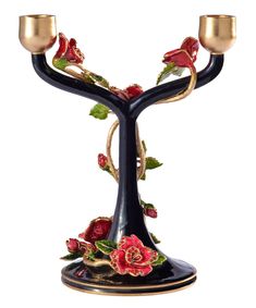 a black candle holder with two candles on it's sides and flowers in the middle