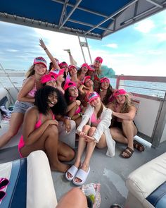 a group of young women sitting on top of a boat next to eachother