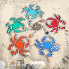 four different colored crabs are on the sand