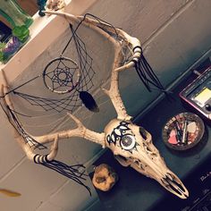 a deer's skull is hanging on the wall next to a compass and other items