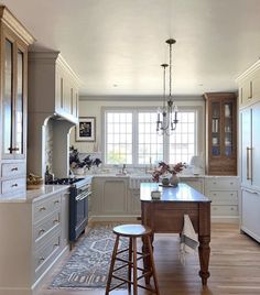 a large kitchen with an island in the middle and two stools at the end