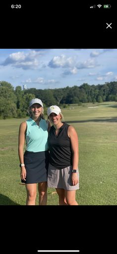 two women standing next to each other on a field