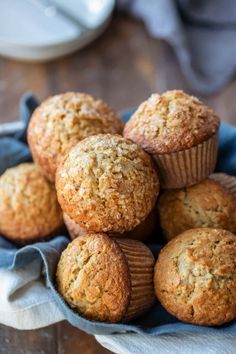 a bunch of muffins sitting on top of a blue cloth in a bowl