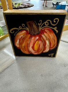 an orange pumpkin painted on a black box