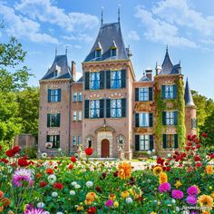 a large building with lots of flowers in front of it