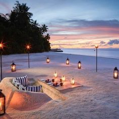 an outdoor seating area with candles on the beach