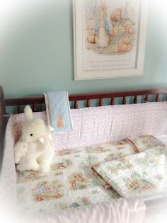 a white stuffed animal sitting on top of a baby crib