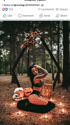 a woman sitting on the ground with pumpkins