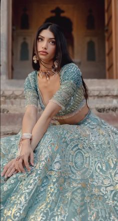 a woman in a blue dress sitting on some steps