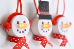 three snowman ornaments with lights on them