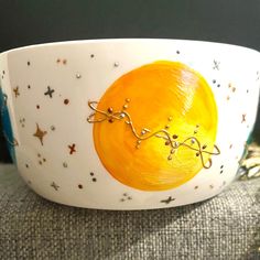 a yellow and white bowl with stars on the bottom is sitting on a gray surface