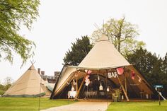 a large tent set up in the middle of a grassy area with tables and chairs