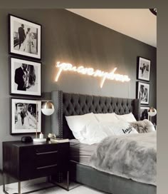 a bedroom with grey walls and pictures on the wall