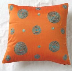 an orange pillow with blue flowers on it