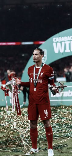 the soccer player is holding his trophy in one hand