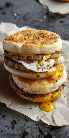 a stack of breakfast sandwiches sitting on top of wax paper