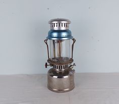 a silver and blue lantern sitting on top of a table