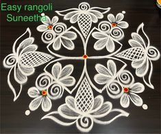 an easy rangdil design with flowers and leaves on black paper, ready to be painted