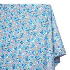 a blue and pink flowered blanket on top of a white background with an image of flowers