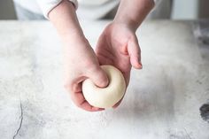 a person is kneading a doughnut on a table with one hand holding the doughnut