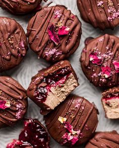 chocolate covered desserts with raspberry filling on a white plate, ready to be eaten