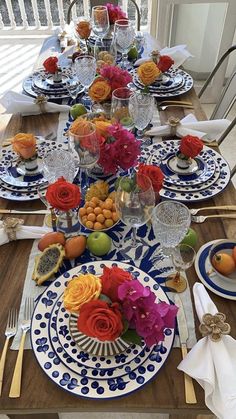 the table is set with plates, silverware and flowers