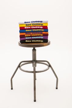 stack of books sitting on top of a metal stool