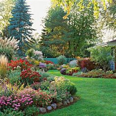 the garden is full of colorful flowers and plants, including trees in the back yard