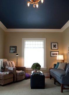 a living room filled with furniture and a chandelier hanging from the skylight