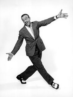 a black and white photo of a man in a suit with his arms outstretched out