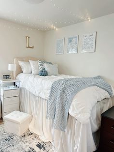 a bedroom with a bed, night stand and two pictures on the wall above it