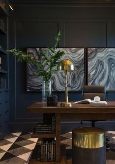 a desk with a lamp and some books on it next to a bookcase filled with books