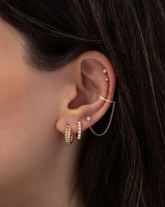 a woman's ear with three different types of piercings