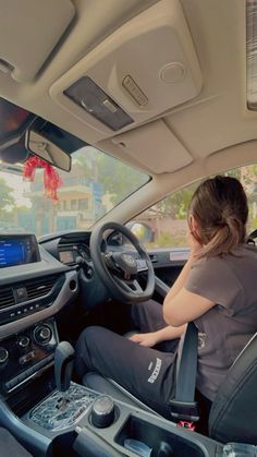 a woman sitting in the driver's seat of a car